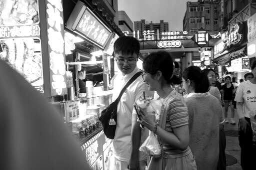 拍摄于山东青岛的夜市，看着其他人的享受美食自己也想食了（
Taken at the night market in Qingdao, Shandong. The joy comes from others when ordering causes me to want to get something to eat. 